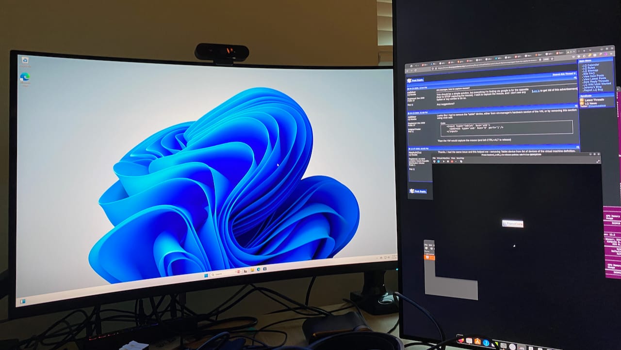 Windows 11 desktop on a curved monitor driven by the passed-through GPU, beside the Ubuntu host monitor on the second GPU.